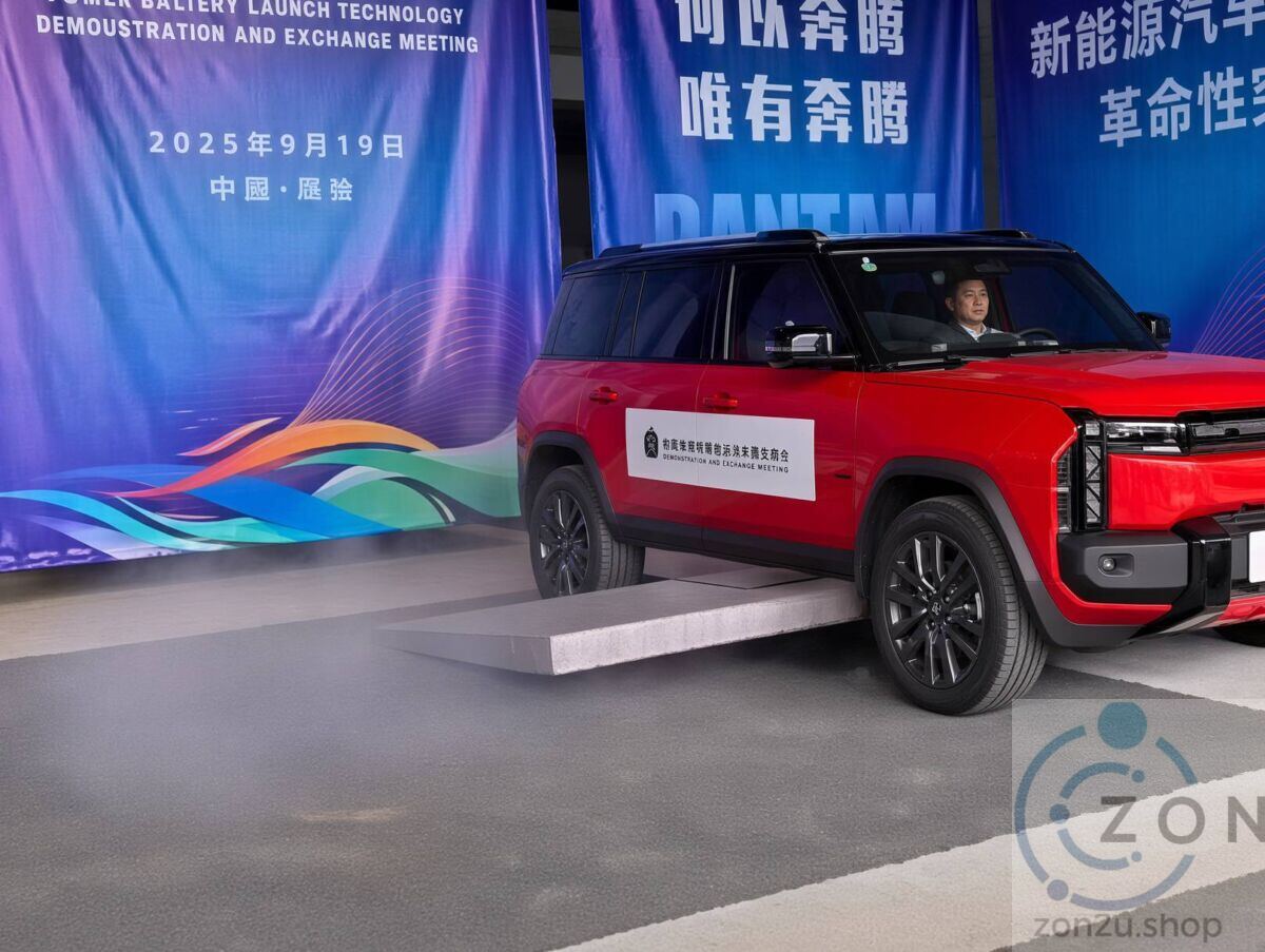 Red SUV driving over a low ramp during a battery technology demonstration event